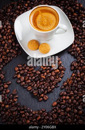 Espresso-Tasse mit Herz aus Kaffeebohnen Stockfoto