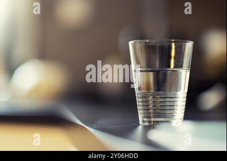 Ein halbes Glas Wasser steht auf dem Küchenschrank Stockfoto