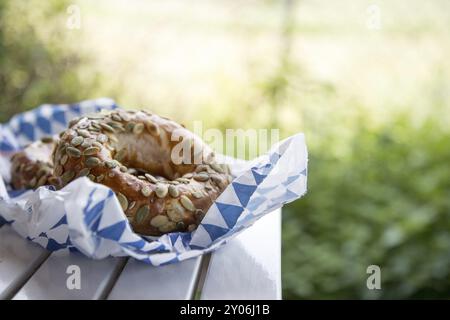 Frische bayerische Pretzels zum Frühstück, liegen auf einem Holztisch im Freien Stockfoto