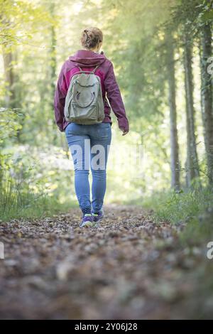Junge Frau geht im Frühling durch den Wald Stockfoto