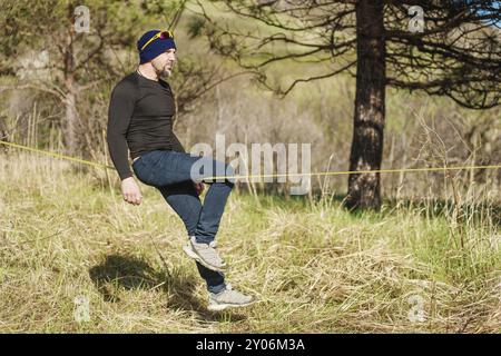 Ein Mann im Alter von Slackline sitzen, Balance finden und das Leben genießen Stockfoto