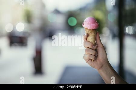 Frau hält Erdbeereis in ihrer Hand, sonnigen Sommertag, verschwommenen Hintergrund Stockfoto