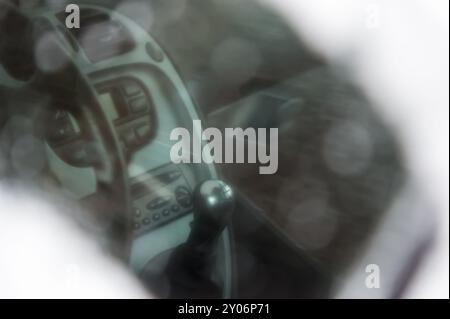 Blick durch ein gefrorenes Seitenfenster in den Innenraum eines Autos. Lenkscheibe, Armaturenbrett, Schaltknauf. Grevenbroich, Nordrhein-Westfalen, Deutschland, Euro Stockfoto