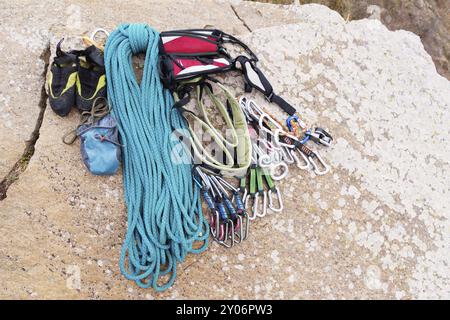 Kletterausrüstung, Tasche für Magnesiumseil und Karbinen aus nächster Nähe. Ein gewickeltes Kletterseil, das als Hintergrund auf dem Boden liegt. Konzept Stockfoto