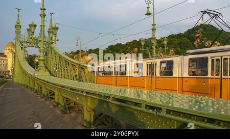 Freiheitsbrücke in Budapest über die Donau. Historische Straßenbahn auf der Brücke Stockfoto