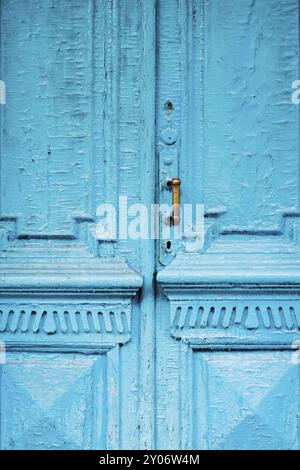 Nahaufnahme von Schlüssellöchern mit Vorhängen und einem Griff auf der blauen, oft gemalten, gerissenen Holztür mit doppeltem Zylinder des letzten Jahrhunderts mit einer Pos. Stockfoto