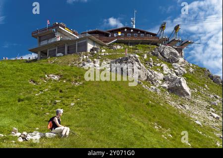 Frau, die unter der Gipfelstation der Nebelhornbahn sitzt Stockfoto