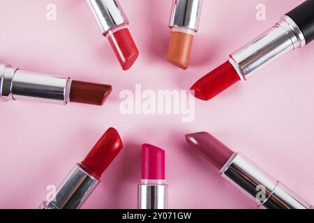 Kollektion verschiedene farbenfrohe Lippenstifte rosa Oberfläche. Schönes Foto Stockfoto