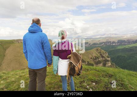 Ein Paar Hipster-Touristen steht nebeneinander in den Bergen vor der Kulisse des Hochplateaus aus Tälern und Himmel. Die Erholung findet man in den mountai Stockfoto