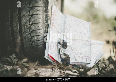 Autoreifen, Sonnenbrillen und Roadmap auf Sandboden, Wüste Stockfoto