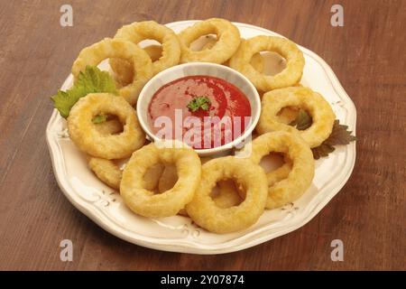 Eine Nahaufnahme von squid Ringe mit einer Tomatensauce auf einem dunklen Hintergrund Stockfoto