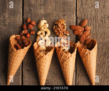 Eis mit organischen Haselnüsse, Cashewkerne, Mandeln und Walnüsse auf einem rustikalen Holztisch Stockfoto