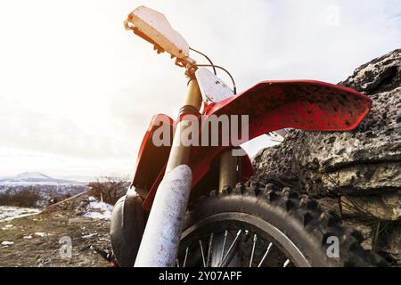 Details zum Enduro-Motorrad. Weitwinkel. Flügel mit dem Rad und einem Stoßdämpfer vor dem Hintergrund des Fels und des Himmels Stockfoto