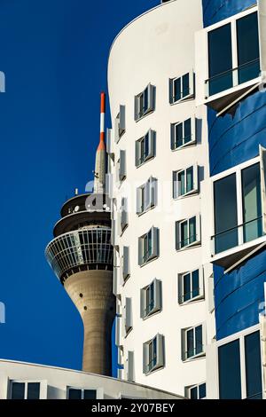 Der Rheinturm hinter den Gehry-Gebäuden im Düsseldorfer Medienhafen Stockfoto
