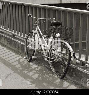 Gebrochenes vergessenes Fahrrad auf einem Brückengeländer in Berlin Stockfoto