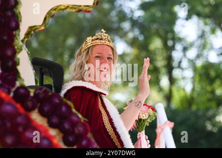 Wahl der Blütenkönigin beim 72. Blütenfest. Blütenkönigin Clematis I Meike Deharde sitzt auf dem Krönungswagen und grüßt das Publikum am Straßenrand. Bei dem traditionellen Blütenfest, einem der größten in Norddeutschland, wird jedes Jahr Anfang September eine neue Blütenkönigin gewählt. Das Blütenfest geht vom 29. August bis zum 2. September. Wiesmoor Niedersachsen Deutschland *** Wahl der Blossom Queen beim Blossom Festival 72 Blossom Queen Clematis i Meike Deharde sitzt auf dem Krönungsfloat und begrüßt das Publikum am Straßenrand beim traditionellen Blossom Festival, einem der La Stockfoto