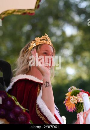 Wahl der Blütenkönigin beim 72. Blütenfest. Blütenkönigin Clematis I Meike Deharde sitzt auf dem Krönungswagen und grüßt das Publikum am Straßenrand. Bei dem traditionellen Blütenfest, einem der größten in Norddeutschland, wird jedes Jahr Anfang September eine neue Blütenkönigin gewählt. Das Blütenfest geht vom 29. August bis zum 2. September. Wiesmoor Niedersachsen Deutschland *** Wahl der Blossom Queen beim Blossom Festival 72 Blossom Queen Clematis i Meike Deharde sitzt auf dem Krönungsfloat und begrüßt das Publikum am Straßenrand beim traditionellen Blossom Festival, einem der La Stockfoto