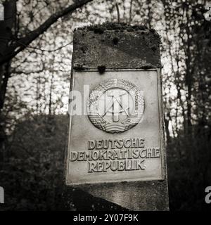 Grenzpfeiler der ehemaligen innerdeutschen Grenze mit dem Wappen der DDR im Wald im Nationalpark Harz Stockfoto