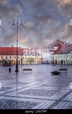 Sibiu, Rumänien, 27. März 2015: Häuser mit berühmten augenförmigen Fenstern auf den Dächern und Menschen auf dem Hauptplatz, Europa Stockfoto