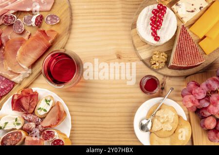 Verkostung Von Wurstwaren. Ein Foto von vielen verschiedenen Würstchen und Schinken, Fleisch zum Mittagessen und einer Käseplatte, von oben auf einem rustikalen Hintergrund mit einer gla aufgenommen Stockfoto
