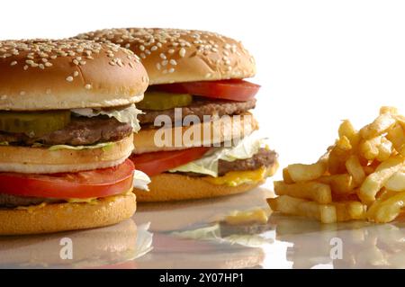 Zwei appetitliche bunte Hamburger und Pommes Frites Essen Stillleben auf weißem Hintergrund mit einem Kopierraum Stockfoto