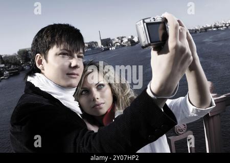 Junger Mann eine junge Frau auf der Brücke selbst mit einer Kamera fotografieren Stockfoto