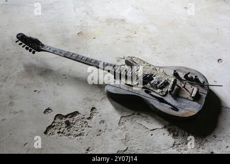 Verbrannte Gitarre auf dem Boden eines verlassenen Hauses in Magdeburg Stockfoto