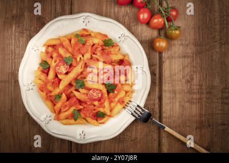 Nudeln mit Tomatensoße und Petersilie, Overhead shot auf einem dunklen Holzmöbeln im Landhausstil Hintergrund mit Copyspace Stockfoto