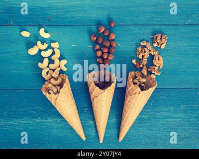 Eis mit organischen Haselnüsse, Cashewkerne und Walnüsse auf einem blauen rustikalen Holztisch Stockfoto