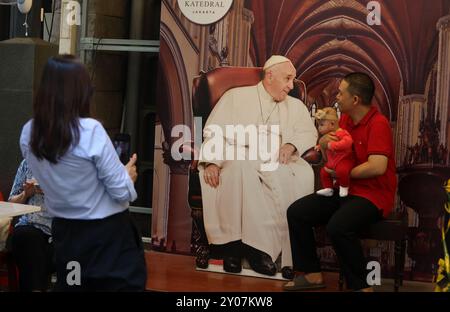 Jakarta, Jakarta, Indonesien. September 2024. Ein Mann und sein Baby machen ein Foto mit einer Dekoration, die Papst Franziskus in der Kathedrale von Jakarta darstellt. Jakarta Cathedral Church vor seinem Besuch in Indonesien vom 3. Bis 6. September 2024 in Jakarta, Sonntag, 1. September 2024. Papst Franziskus wird vom 2. Bis 13. September 2024 eine apostolische Reise nach Indonesien, Papua-Neuguinea, Timor-Leste und Singapur Unternehmen. Indonesien ist das erste Land in der Serie von Besuchen. (Kreditbild: © Antonius Jagad SR/ZUMA Press Wire) NUR REDAKTIONELLE VERWENDUNG! Nicht für kommerzielle ZWECKE! Stockfoto