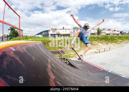 Junge, der einen Trick macht mit einem Sprung auf der Rampe im Skatepark. Foto mit einem Platz für den Kopierbereich Stockfoto