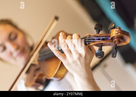 Hübsches junges Mädchen übt auf ihrer Violine, akustische Musik Stockfoto