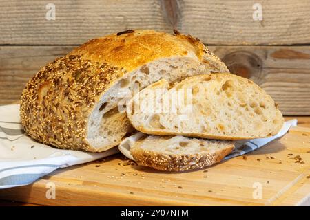 Hausgemachtes frisches Brot und Scheiben auf dem Küchentisch. Sauerteig Weizen Roggenbrot mit Samen aus der Nähe Stockfoto