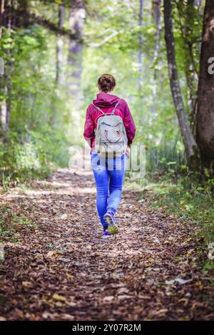 Junge Frau geht im Frühling durch den Wald Stockfoto