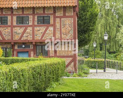 Gepflegter Gartenweg in einem Fachwerkhaus mit Hecken und Laternen, eingebettet in grüne Bäume, ystad, schweden, ostsee, skandinavien Stockfoto