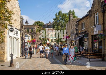 Die Leute genießen die Sommersonne in den Bars und Cafés in der Marktstadt Hebden Bridge in West Yorkshire im Calderdale Valley, England Stockfoto