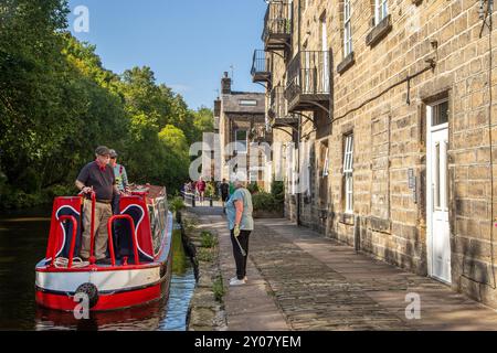 Menschen auf einem Kanalschmalboot, das auf dem Rochdale-Kanal in der Marktstadt Hebden Bridge England im West Yorkshire Calderdale Valley vor Anker gehen soll Stockfoto
