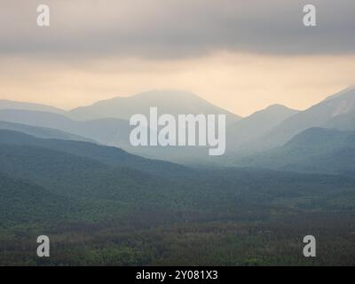 Ein atemberaubender Blick vom Gipfel des Mt. Van Hoevenberg, wo die Adirondack Mountains in Schichten durch einen nebeligen Dunst in der Nähe des Lake Placid, New, auftauchen Stockfoto