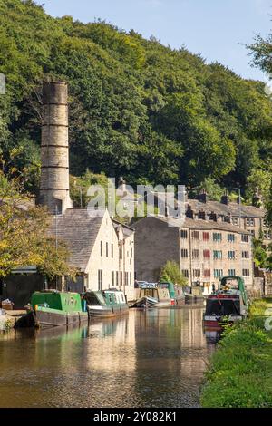 Canal Schmalboote, die von der ehemaligen Crossleys Mühle am Rochdale Kanal in der Calderdale Valley Marktstadt Hebden Bridge West Yorkshire England vertäut wurden Stockfoto