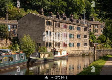 Canal Schmalboote vertäuten neben ehemaligen Weberhütten am Rochdale-Kanal in der Stadt Hebden Bridge England in Calderdale West Yorkshire Stockfoto