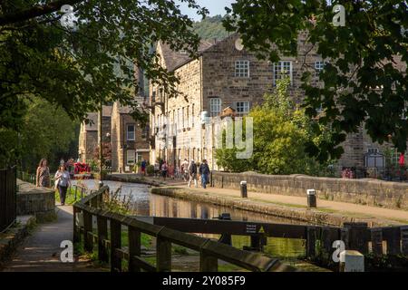 Menschen und Touristen, die an alten Textilfabriken entlang des Rochdale-Kanals in der Marktstadt Hebden Bridge England in West Yorkshire vorbeilaufen Stockfoto