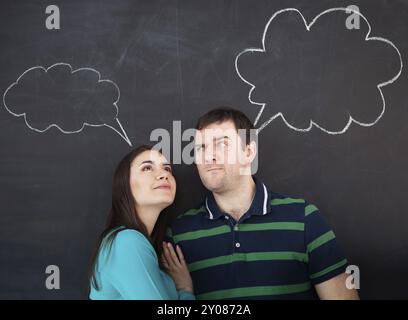 Junge glückliche Paare denken. Kreidezeichnung auf dunklem Hintergrund Stockfoto