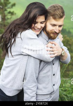 Junges Liebespaar entspannen und umarmt, sie lächelt und stützte sich auf seine Schulter, Beziehungen und Gefühle Konzept Stockfoto