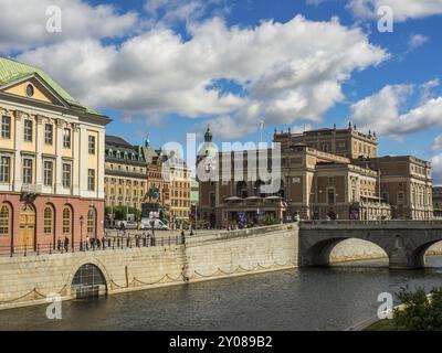 Blick auf die Stadt mit historischen Gebäuden, Fluss und Brücke unter teilweise bewölktem Himmel, stockholm, ostsee, schweden, skandinavien Stockfoto