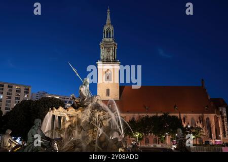 Neptunbrunnen von 1891 und Marienkirche bei Nacht in Berlin. Stockfoto