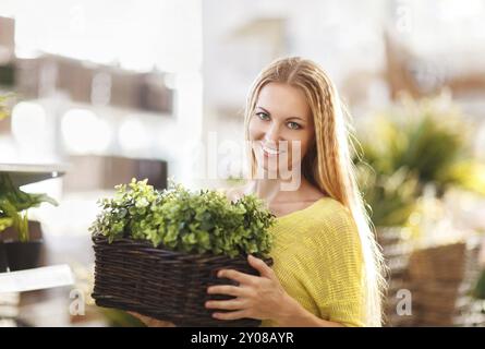 Junge Frau, die Blumen in einem Garten-Center zu kaufen. Flachen DOF Stockfoto