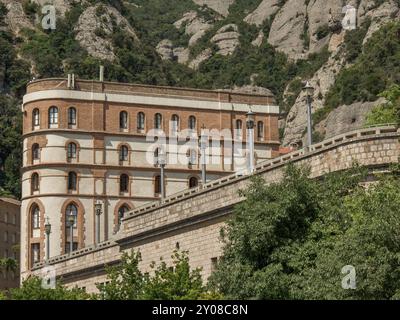 Ein historisches Gebäude mit roten Ziegeln und Steinmauer unter einem klaren blauen Himmel, montserrat, spanien Stockfoto