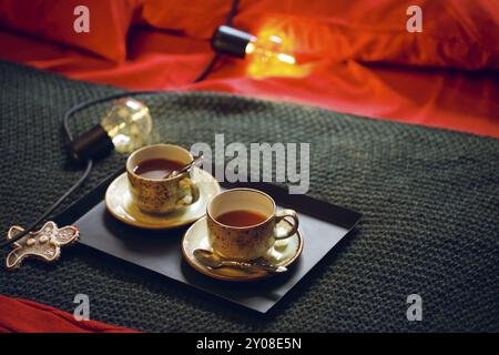 Weihnachtsdekoration und Teetasse auf dem Bett. Draufsicht Stockfoto