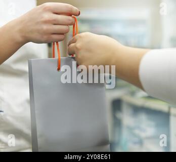 -Shopping-Konzept. Junge Frau etwas in Papiertüte zu kaufen und bekommen es vom Verkäufer Stockfoto