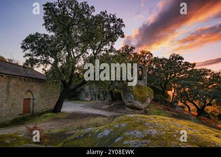 Alte Ruine Steingebäude bedeckt mit Moos in der Nähe der Kapelle Sao Pedro mit Bäumen und Felsblöcken in Monsanto, Portugal, Europa Stockfoto